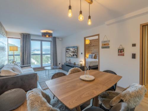 un salon avec une table et des chaises en bois dans l'établissement Appartement Neuf 65m² Courchevel Moriond, 2 Chambres + Cabine, Balcon, Parking Couverts, Skis aux Pieds - FR-1-563-127, à Courchevel