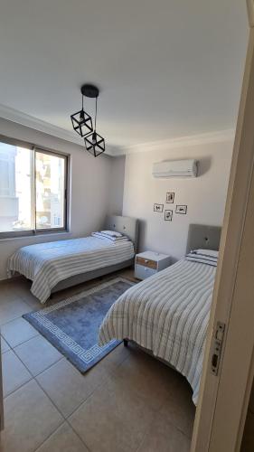 1 dormitorio con 2 camas y ventana en Nimet Aydın Apartmanı, en Alanya