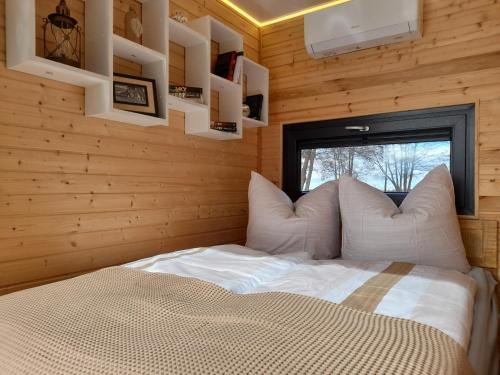 a bedroom with a bed in a wooden wall at Hausboot am See in Rieth