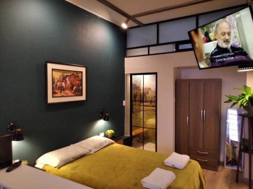 a bedroom with a bed and a flat screen tv at Estudio Industrial in Huancayo