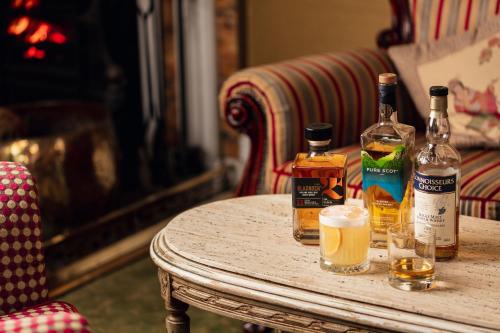a table with bottles of whiskey and glasses on it at Cally Palace Hotel & Golf Course in Gatehouse of Fleet