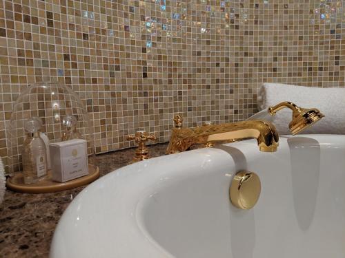 a bathroom with a white sink and a gold faucet at InterContinental Bordeaux Le Grand Hotel by IHG in Bordeaux