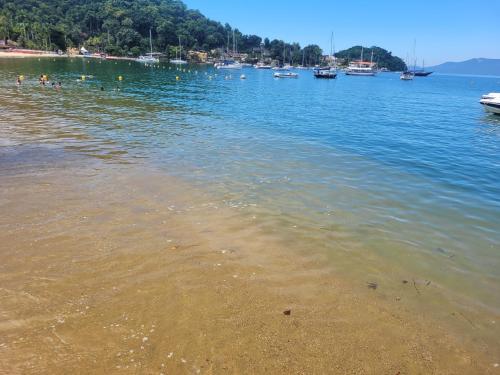 a group of people swimming in a body of water at Angra Inn, Angra dos Reis - Mar, Sol e Piscina in Angra dos Reis