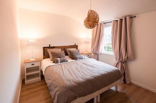 une chambre avec un grand lit et une fenêtre dans l'établissement CHEZ FLO, à Saint-Léonard