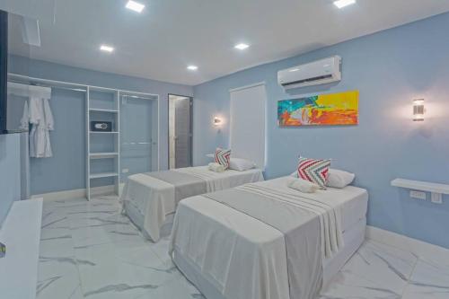 two beds in a room with blue walls at Beautiful 7BDR Home by Isla Mujeres Ferry in Cancún