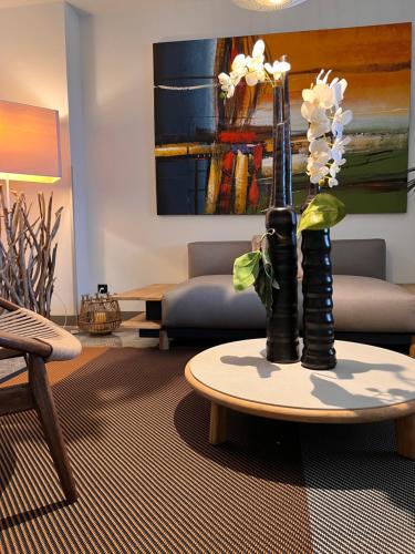a living room with a table with a vase with flowers at Santateresa in Bonifacio