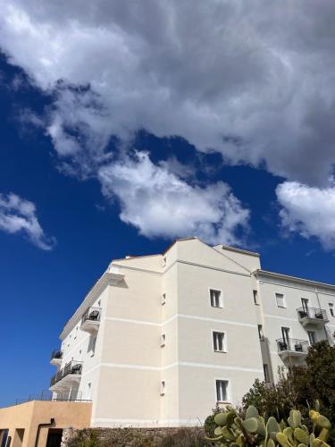 a white building against a blue sky with clouds at Santateresa in Bonifacio