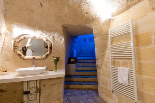 a bathroom with a sink and a blue staircase at Thymus Residence nei Sassi in Matera