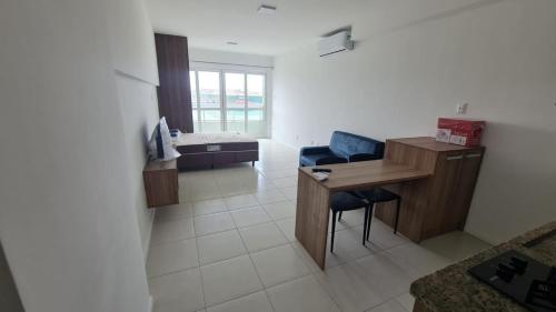 Habitación con escritorio y silla azul. en Acqua Vert Residence & Loft - Em frente a Praia de Armação e Centro de Convenções, en Salvador