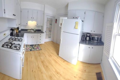 a kitchen with white appliances and a wooden floor at The Sailing Gypsy and Bunkie incl in pricing June 22-Sept 14 in Port Elgin