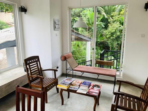 a living room with a table and chairs and a window at Everdew Kandy in Kandy