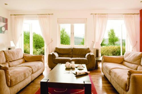 a living room with two couches and a coffee table at Ring Of Kerry Holiday Cottages No 20 by Trident Holiday Homes in Kenmare