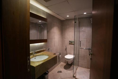 W łazience znajduje się umywalka, toaleta i prysznic. w obiekcie Palm Boutique Hotel w mieście Dżudda