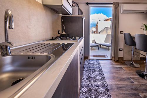 a kitchen with a sink and a stove at Casa Vacanze RetroScena in Avola