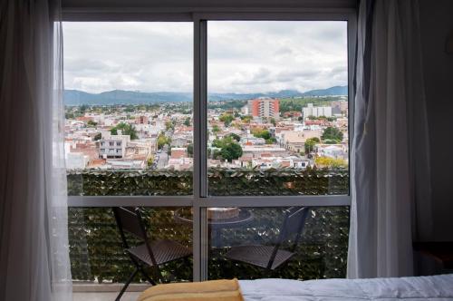 ein Schlafzimmerfenster mit Stadtblick in der Unterkunft Departamento los Poetas in Salta