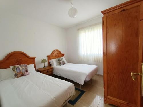 1 dormitorio con 2 camas y ventana en FINCA AMEIROS, en O Grove