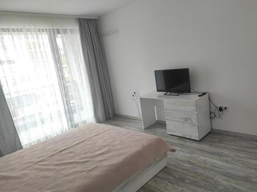 a bedroom with a bed and a flat screen tv at Апартамент Памела ВИП гр. Добрич in Dobrich