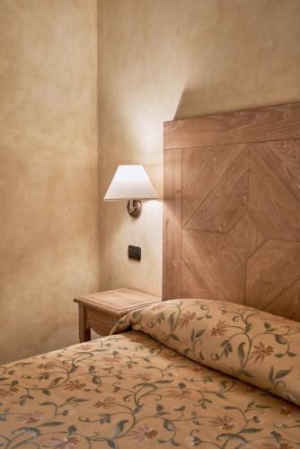 a bedroom with a bed and a lamp on a table at Borgo Lanciano in Castelraimondo