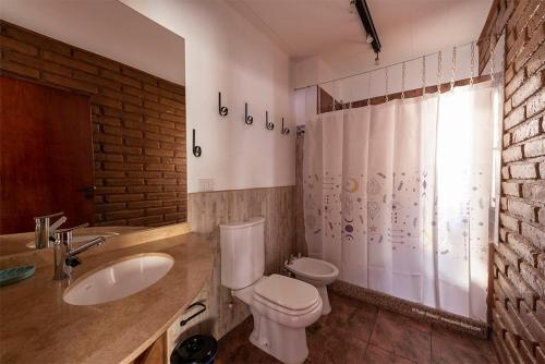 a bathroom with a white toilet and a sink at Casa de Peter in Cafayate