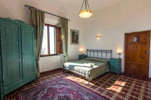 una camera da letto con un letto con armadi verdi e un tappeto di Hotel Villa Porta All'Arco a Volterra