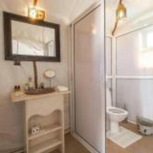 a bathroom with a glass shower and a toilet at Merzouga heart camp in Merzouga