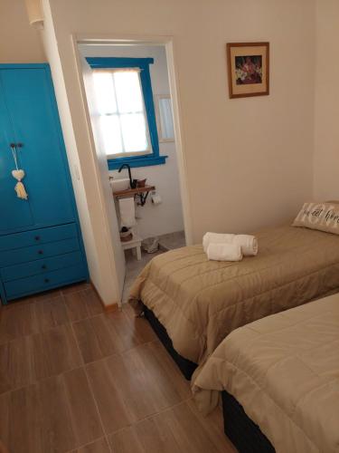 um quarto com 2 camas e um armário azul em Aristobulo em Buenos Aires