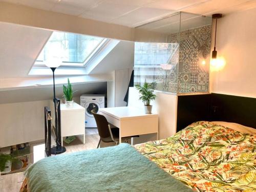 een slaapkamer met een bed, een bureau en een raam bij Chez Valentine au coeur des Buttes Chaumont et Belleville in Parijs