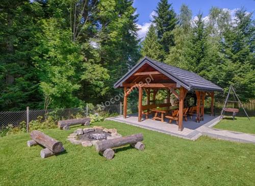 a gazebo with a picnic table and a fire pit at Domki Letniskowe SOBALSKI in Zawoja