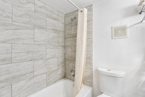 a bathroom with a white tub and a toilet at FairBridge Inn and Suites West Point in Highland Falls