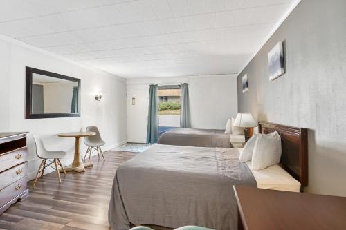 a hotel room with a bed and a table and chairs at FairBridge Inn and Suites West Point in Highland Falls