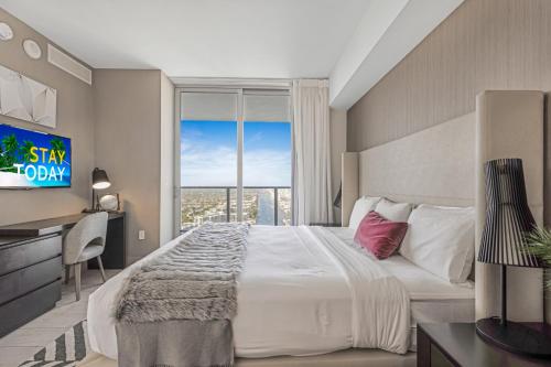 a bedroom with a large bed and a large window at Hyde Beach House - Luxury 2-Bedroom - Gorgeous view - Resort amenities - Rooftop pool - Hot tub - Tennis court - Minutes to the ocean in Hollywood