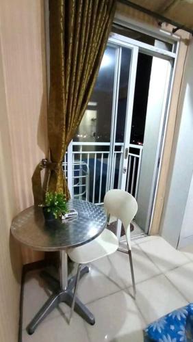 een tafel en 2 stoelen in een kamer met een raam bij Bogor Valley Apartment in Bogor