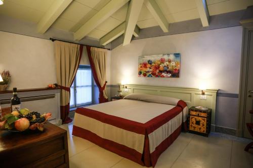 1 dormitorio con 1 cama y una pintura en la pared en NaturalMente Wine Resort en Agliano Terme