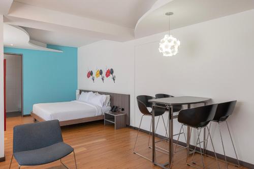a bedroom with a bed and a table and chairs at Hotel Viaggio 617 in Bogotá