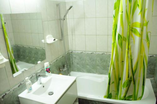 a bathroom with a sink and a shower and a tub at Decebal 1 Premium apartment in Bucharest