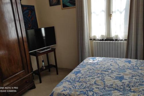 Schlafzimmer mit einem Bett und einem Flachbild-TV in der Unterkunft Popi al mare in villa con giardino e wifi in Sestri Levante