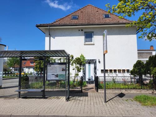 a bus stop in front of a white building at A Comfortable and Modern Newly Renovated Apartment in Mannheim