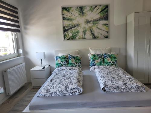 a bedroom with two beds and a painting on the wall at A Comfortable and Modern Newly Renovated Apartment in Mannheim