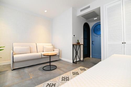 a living room with a white couch and a table at Borelli Palace & Borelli Blue in Zadar