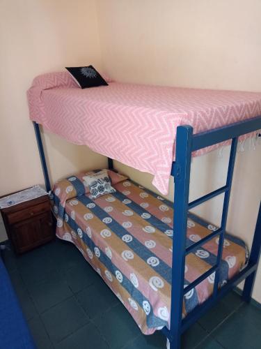 a bunk bed in a room with a bedsheet at TU LUGAR in Villa Cura Brochero