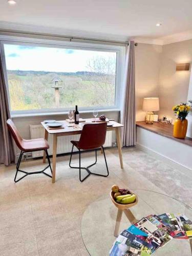 a living room with a table and chairs and a window at Treetops Cottage at Treetops Hideouts in Richmond