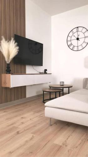 un salon blanc avec une télévision et un canapé dans l'établissement Charmant appartement avec terrasse et parking - Centre ville, à Chartres