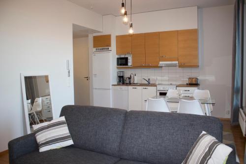 een woonkamer met een bank en een keuken bij MM City Apartment Ratina Close to Arena in Tampere