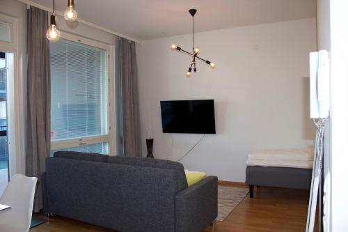 uma sala de estar com um sofá e uma televisão de ecrã plano em MM City Apartment Ratina Close to Arena em Tampere