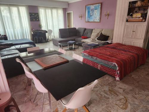 un salon avec une table et un canapé dans l'établissement Big apart 140m2 5min walk to beach sea &Promenade 3 double rooms,big living room 42m2, 3 showers,9 beds, free parking, à Nice
