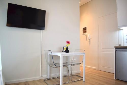a white table with two chairs and a tv on a wall at KAPA Central Apartment in Kalamata