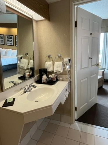 La salle de bains est pourvue d'un lavabo et d'un grand miroir. dans l'établissement Sleep Inn Lynchburg - University Area & Hwy 460, à Lynchburg