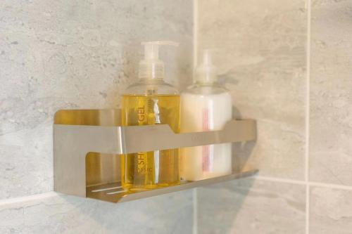 un distributeur de savon avec deux bouteilles sur un mur dans l'établissement WV Top Flat Bowness Center, à Bowness-on-Windermere