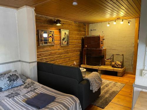 a bedroom with a bed and a fireplace at Mentulan Cottage in Lappeenranta