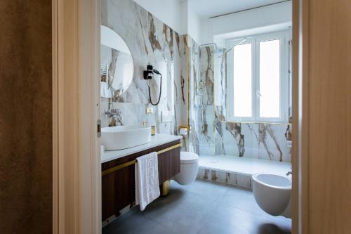 bagno con 2 lavandini, servizi igienici e vasca di Elegant Apartments 5 terre la spezia a La Spezia